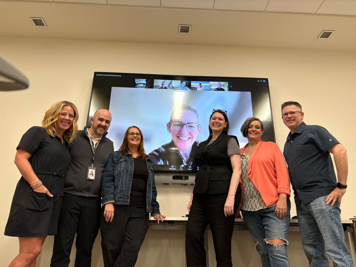 Six Peak Perspectives book club members standing in front of a screen showing members who joined by video