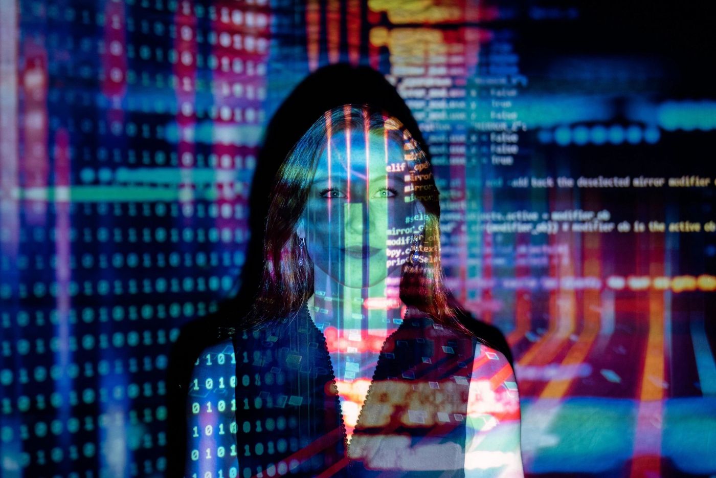 Woman lit by projected lines of computer code